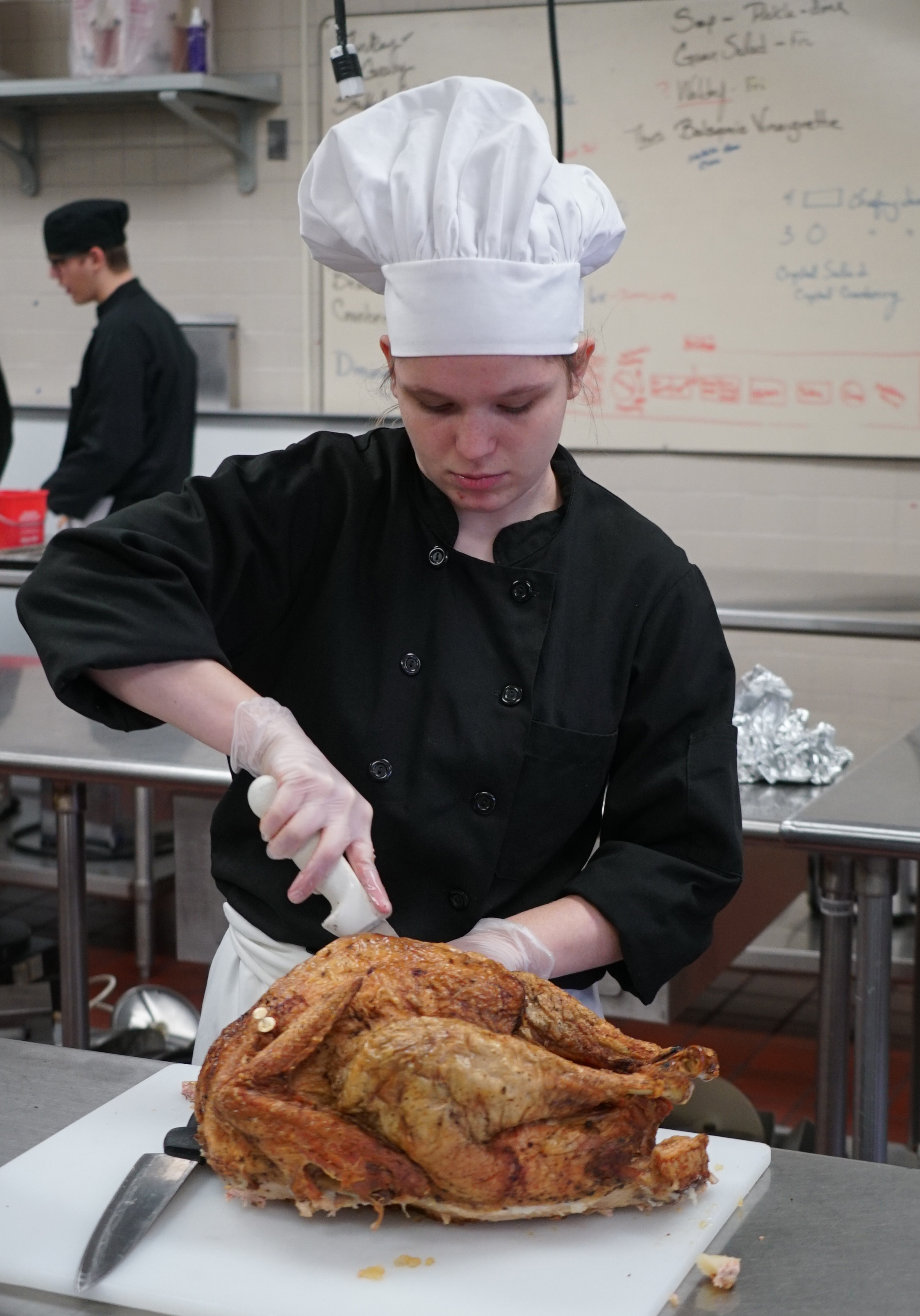 student carving turkey